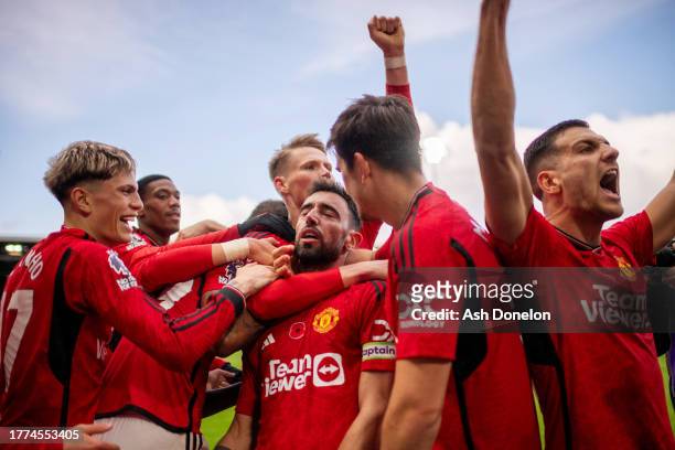 Bruno Fernandes of Manchester United celebrates with team mates after scoring their sides first goal during the Premier League match between Fulham...