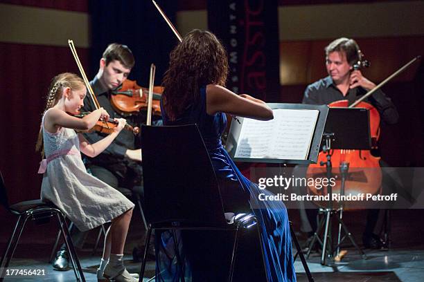 English 8-year-old violin prodigy, Alma Deutscher performs a piece of her own composition alongside, from left, violonists Michael Rudoy and Julia...