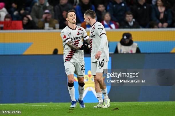 Alex Grimaldo of Bayer Leverkusen celebrates with teammate Florian Wirtz after scoring the team's second goal during the Bundesliga match between TSG...