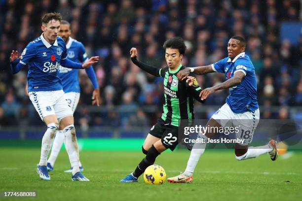 Kaoru Mitoma of Brighton & Hove Albion is challenged by Ashley Young of Everton during the Premier League match between Everton FC and Brighton &...