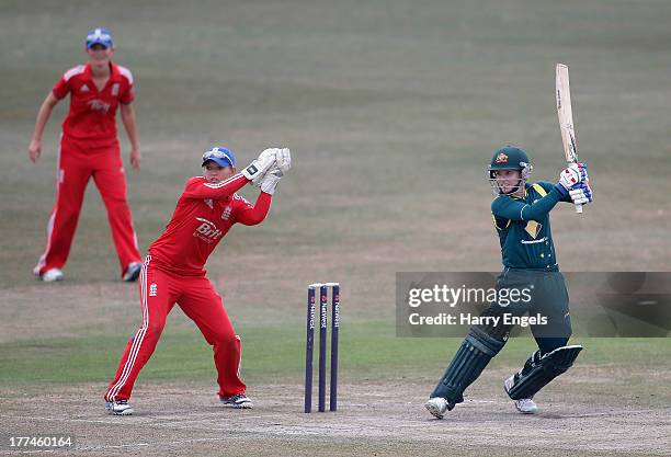 Jodie Fields of Australia hits out as England wicketkeeper Sarah Taylor looks on during the second NatWest One Day International match between...