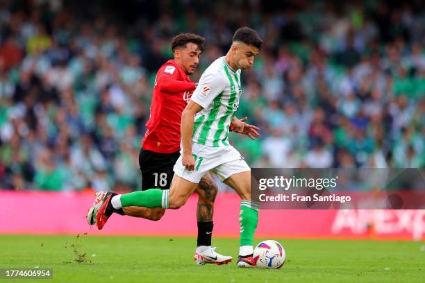 Antonio Sanchez of RCD Mallorca challenges Marc Roca of Real Betis during the LaLiga EA Sports match between Real Betis and RCD Mallorca at Estadio...