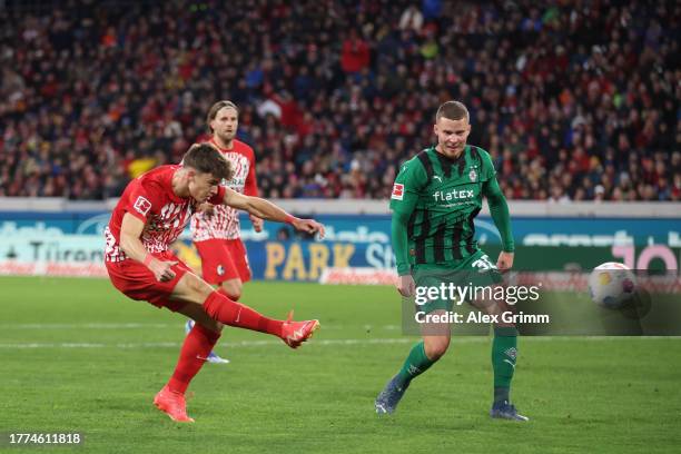 Noah Weisshaupt of Sport-Club Freiburg scores the team's second goal whilst under pressure from Nico Elvedi of Borussia Moenchengladbach during the...