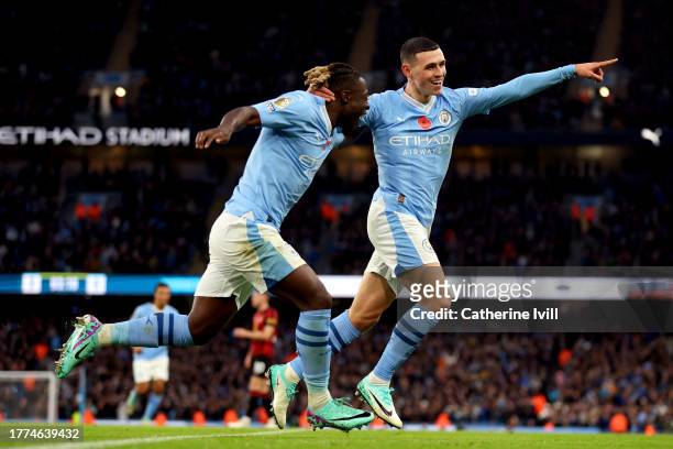 Phil Foden of Manchester City celebrates with Jeremy Doku of Manchester City after scoring the team's fourth goal during the Premier League match...