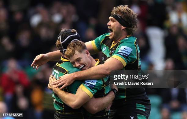 Alex Coles of Northampton Saints celebrates with team mates Fin Smith and Angus Scott-Young after scoring their second try during the Gallagher...