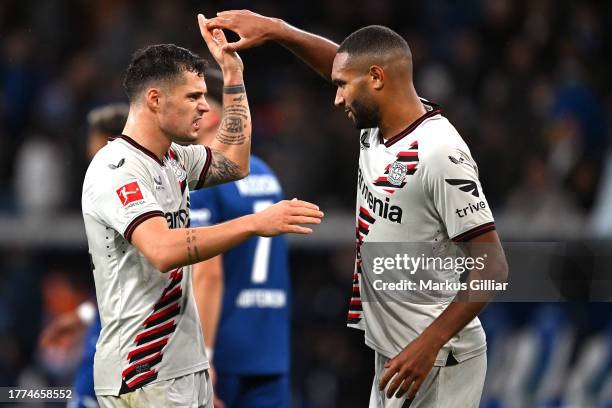 Granit Xhaka of Bayer Leverkusen celebrates with teammate Jonathan Tah following the team's victory during the Bundesliga match between TSG...