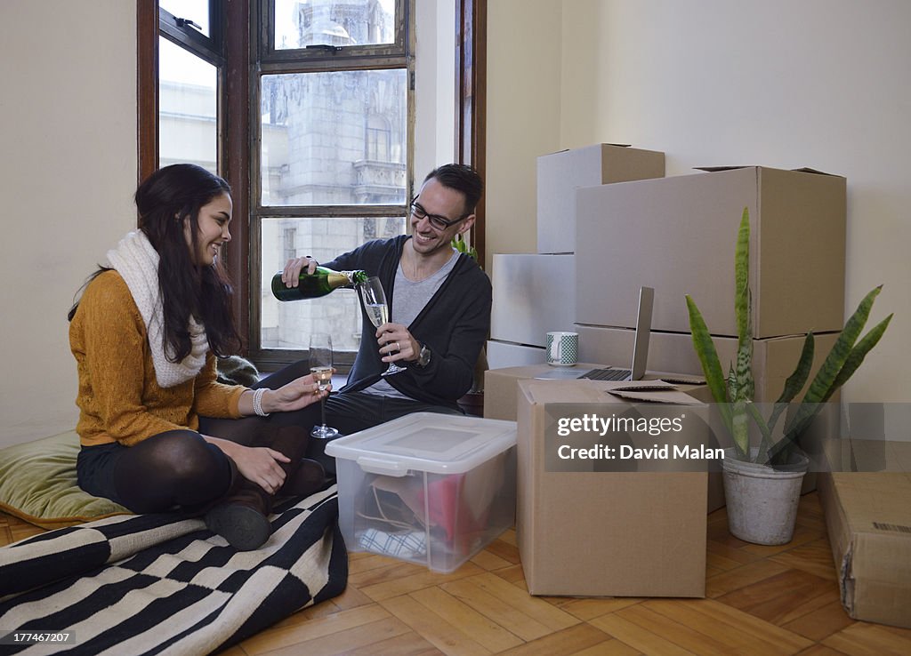 Couple pouring champagne in their new apartment