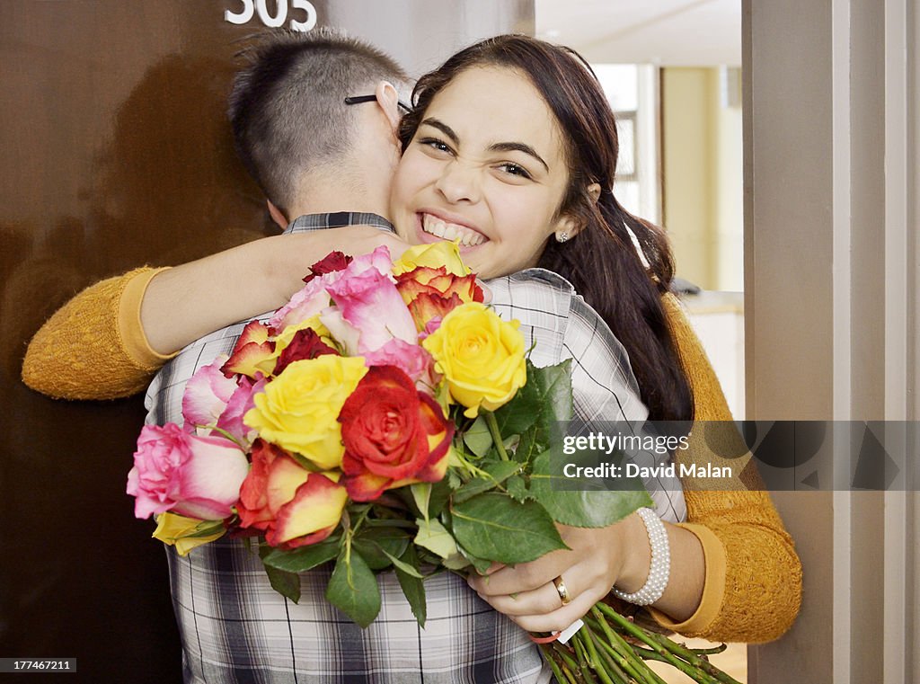 Happy young woman having received flowers.