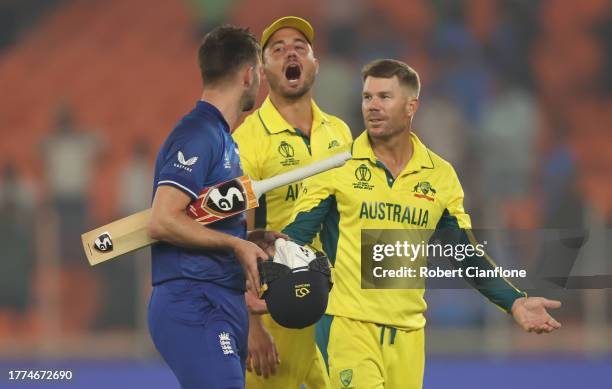 Mark Wood of England interacts with Marcus Stoinis and David Warner of Australia following the ICC Men's Cricket World Cup India 2023 between England...