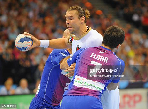 Matthias Flohr of Hamburg is challenged by Bartlomiej Jaszka of Berlin during the second leg of the EHF Champions League play off game between and...