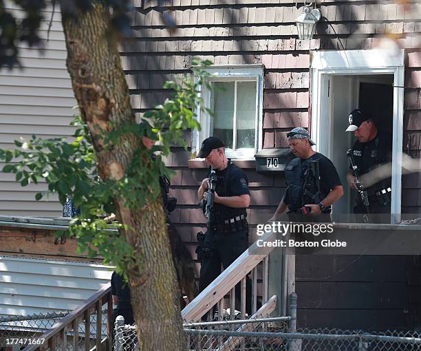 Boston Police SWAT team members leave a residence that was searched, as law enforcement looked for a shooting suspect. Scene and search of area near...