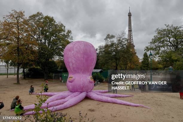 Greenpeace activists stand next to a giant Octopus as they demonstrate in front of the Eiffel Tower against the Prime Minister of Norway Jonas Gahr...