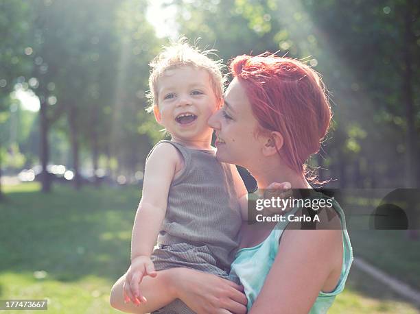 young mom holding her baby - babyhood stock pictures, royalty-free photos & images