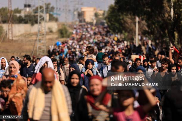 Palestinian families fleeing Gaza City and other parts of northern Gaza towards the southern areas, walk along a road on November 10, 2023 amid...
