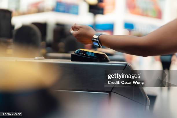 female hand making contactless payment with smart watch to pass through ticket gate at train station - reloj inteligente fotografías e imágenes de stock