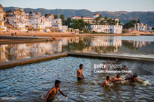Group of people enjoying bath in the afternoon at Pushkar lake. This lake is located in the town of Pushkar in Ajmer district of the Rajasthan, India.