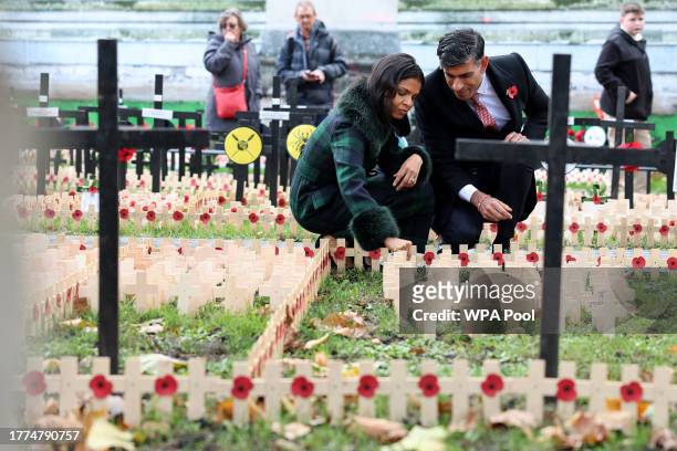Britain's Prime Minister Rishi Sunak and his wife Akshata Murty place Remembrance Crosses in the Field of Remembrance at Westminster Abbey ahead of...