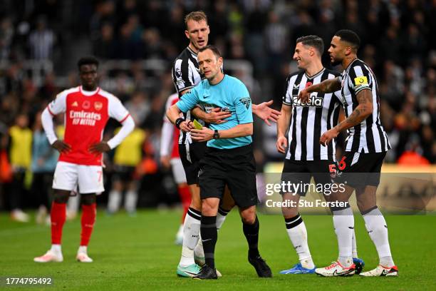 Referee, Stuart Attwell is confronted by Dan Burn, Fabian Schaer and Jamaal Lascelles of Newcastle United during the Premier League match between...