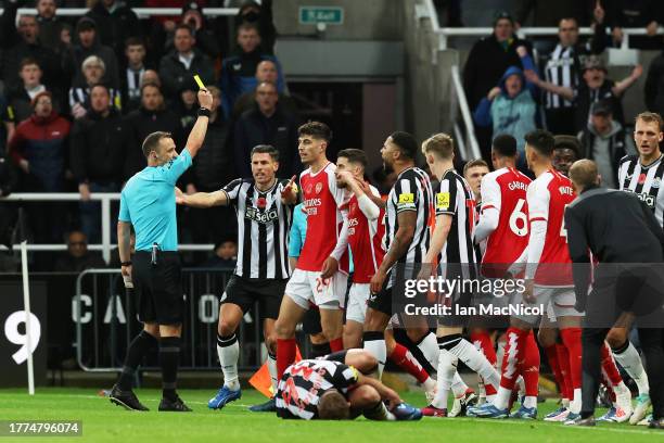 Referee, Stuart Attwell shows a yellow card to Kai Havertz of Arsenal during the Premier League match between Newcastle United and Arsenal FC at St....