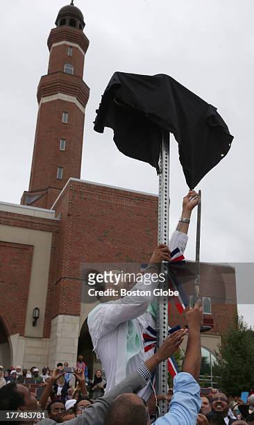 Mahmud Ahmad of Boston uses a knife to bring down the cloth covering. Members of the Islamic Society of Boston Cultural Center and Mayor Thomas M....