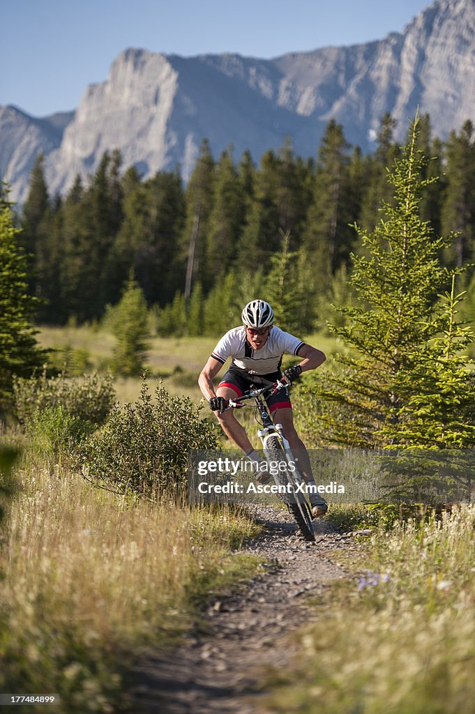 Mountain biker races downhill on mtn path