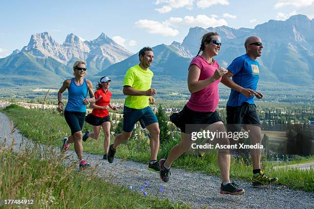 runners race along path, in mountains - running shorts fotografías e imágenes de stock