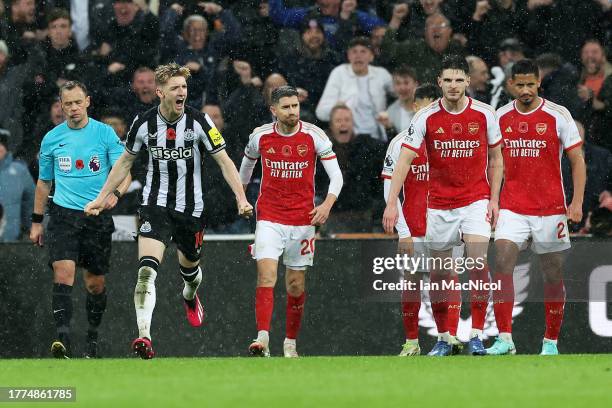 Jorginho, Declan Rice and William Saliba of Arsenal look dejected as Anthony Gordon of Newcastle United celebrates after scoring the team's first...