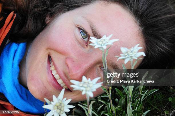 smily face of young woman with edelweiss flowers - edelweiss stock pictures, royalty-free photos & images