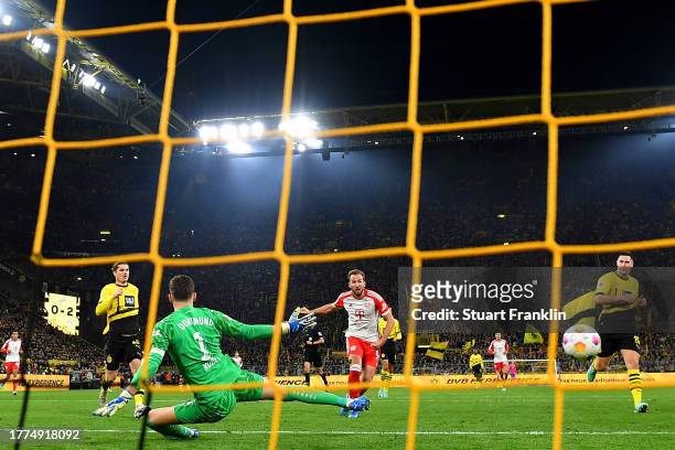 Harry Kane of Bayern Munich scores the team's third goal past Gregor Kobel of Borussia Dortmund during the Bundesliga match between Borussia Dortmund...