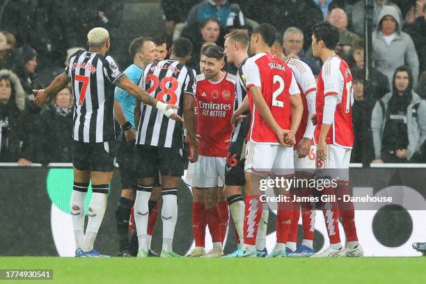 Arsenal players surround referee Stuart Atwell after Newcastle United score their first goal during the Premier League match between Newcastle United...