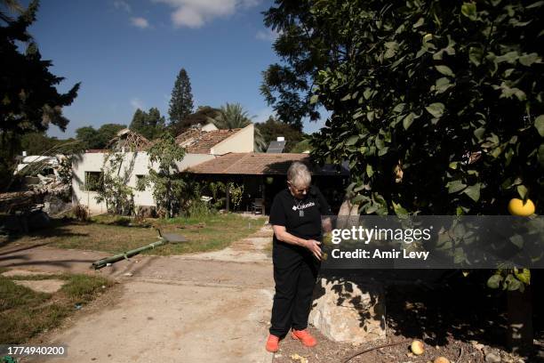 Varda Goldstein peels pomelo she picked from a tree near her house as she visits the kibbutz for the first time after Oct7th Hamas' attack on the...