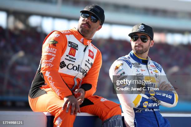 Bubba Wallace, driver of the Columbia Sportswear Company Toyota, and Chase Elliott, driver of the NAPA Auto Parts Chevrolet, wait on the grid during...