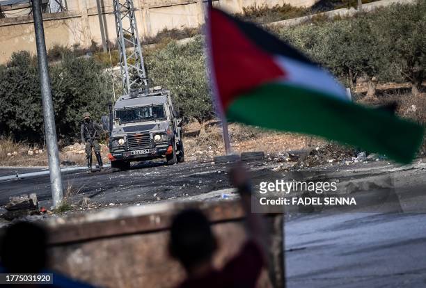 Israeli forces keep watch as Palestinians demonstrate in Ramallah in the occupied West Bank on November 10 amid ongoing battles between Israel and...
