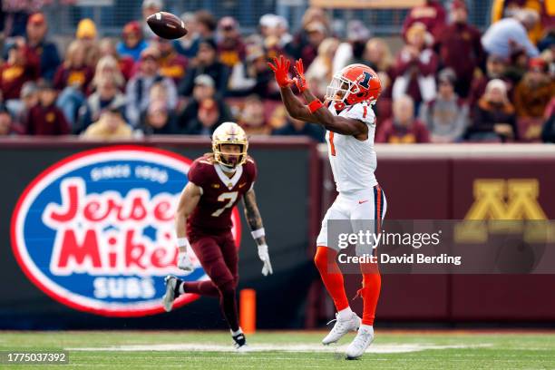 Isaiah Williams of the Illinois Fighting Illini catches a pass while Aidan Gousby of the Minnesota Golden Gophers defends in the first half at...