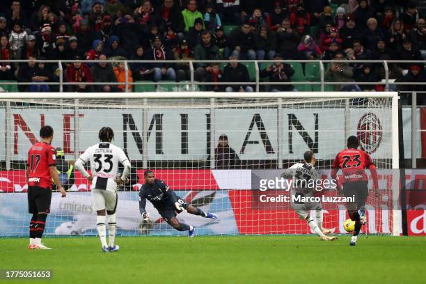 Roberto Pereyra of Udinese Calcio scores the team's first goal past Mike Maignan of AC Milan from the penalty spot during the Serie A TIM match...