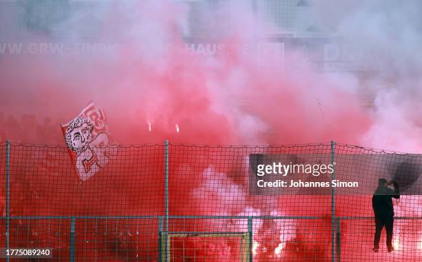Supporters of Regensburg burn fireworks during the 3. Liga match between TSV 1860 München and Jahn Regensburg at Stadion an der Gruenwalder Straße on...