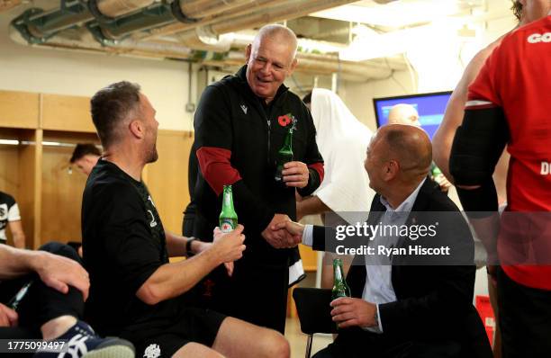 Warren Gatland , Head Coach of Wales, shakes hands with Eddie Jones, Coach of Barbarians, as he speaks with Mark Jones, Coach of Barbarians, in the...