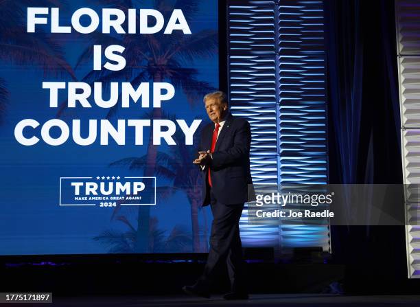 Republican presidential candidate former U.S. President Donald Trump claps during the Florida Freedom Summit at the Gaylord Palms Resort on November...