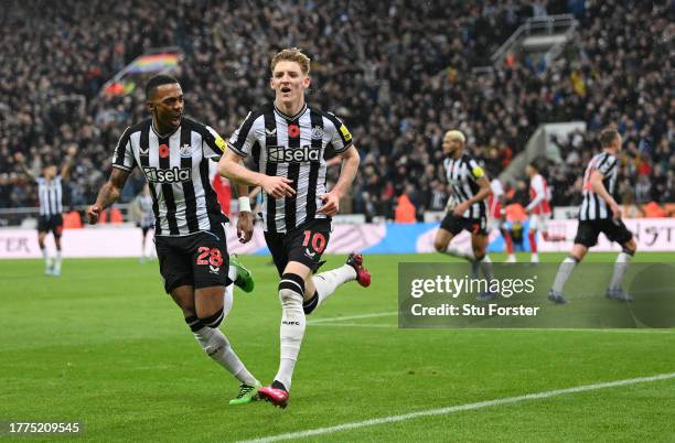 Newcastle player Anthony Gordon celebrates with Joe Willock after scoring the winning goal during the Premier League match between Newcastle United...