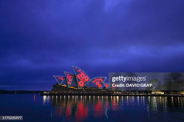 The Sydney Opera House is illuminated with poppies at sunrise to commemorate Remembrance Day in Sydney on November 11, 2023.