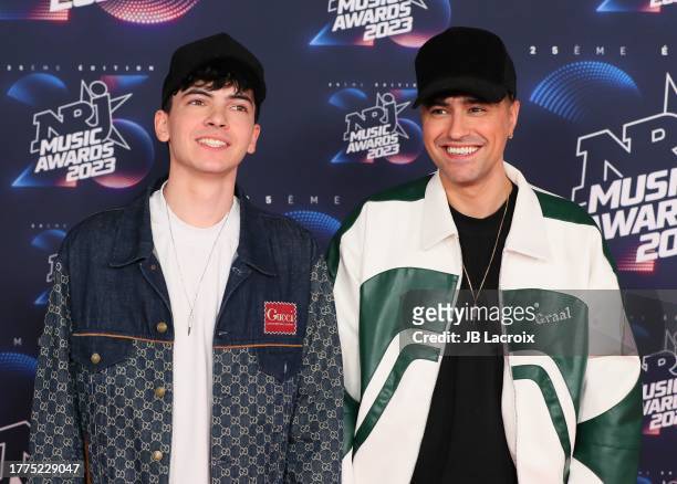 Josh Chergui and Lois Serre of the band Trinix attend the 25th NRJ Music Awards on November 10, 2023 in Cannes, France.