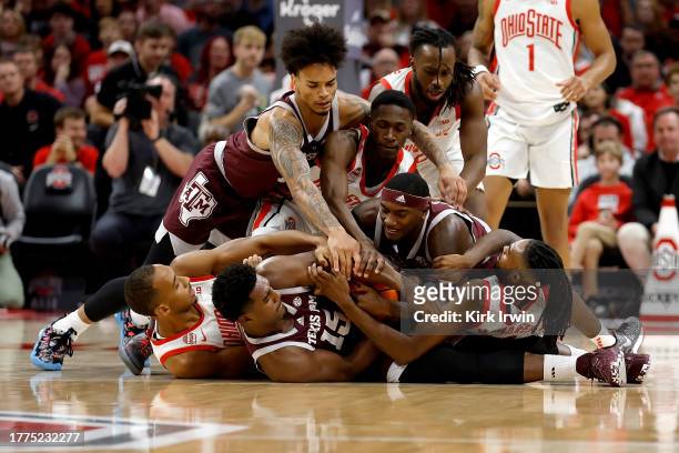 Henry Coleman III of the Texas A&M Aggies attempts to hold on to the ball as players from both the Aggies and the Ohio State Buckeyes battle for...