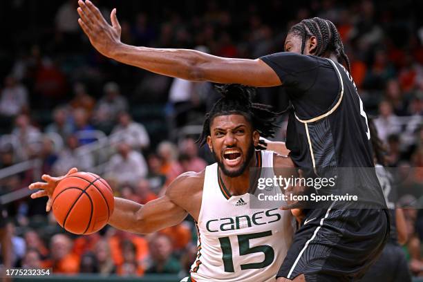 Miami forward Norchad Omier attempts to drive to the basket while defended by UCF forward Omar Payne in the first half as the Miami Hurricanes faced...