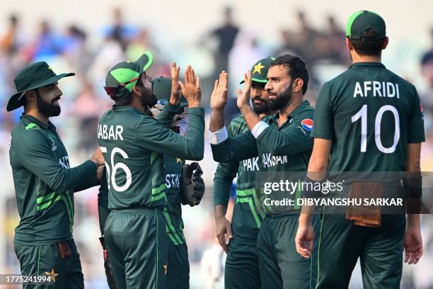 Pakistan's Iftikhar Ahmed celebrates with teammates after taking the wicket of England's Dawid Malan during the 2023 ICC Men's Cricket World Cup...