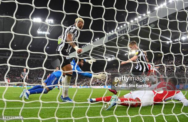 Newcastle player Joelinton and Arsenal defender Gabriel look on as Anthony Gordon fires home past David Raya for the Newcastle winning goal during...