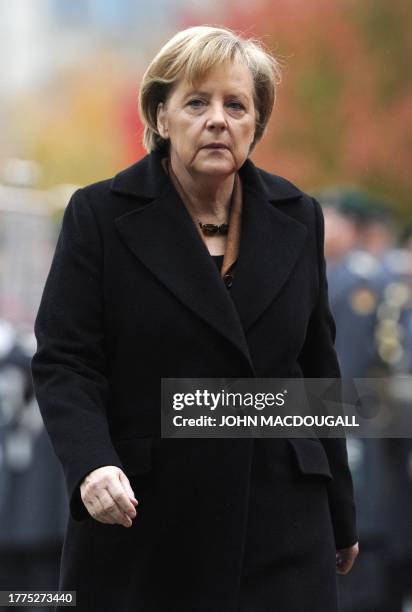 German Chancellor Angela Merkel walks back to the chancellery after greeting German soldiers forming an honour guard prior to the arrival of Chilean...