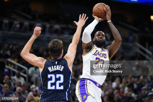 LeBron James of the Los Angeles Lakers shoots over Franz Wagner of the Orlando Magic during the first quarter at Amway Center on November 04, 2023 in...