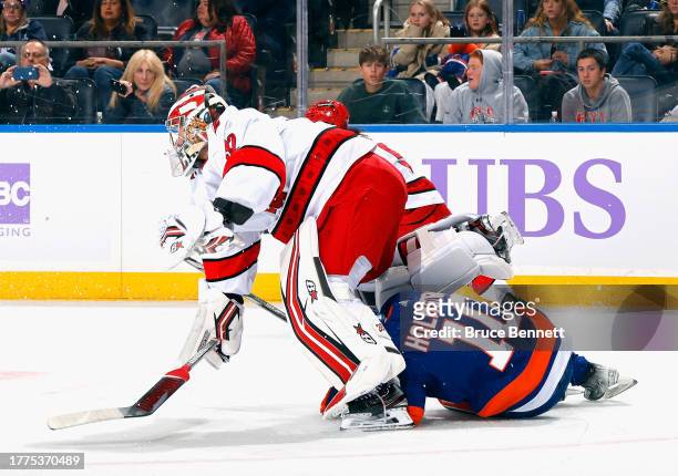 Simon Holmstrom of the New York Islanders slides under Antti Raanta of the Carolina Hurricanes during the second period at UBS Arena on November 04,...