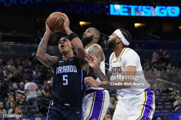 Paolo Banchero of the Orlando Magic drives past LeBron James and Anthony Davis of the Los Angeles Lakers during the second half at Amway Center on...