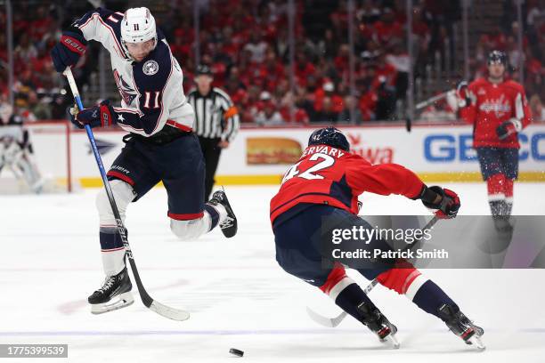 Adam Fantilli of the Columbus Blue Jackets skates past Martin Fehervary of the Washington Capitals during the third period at Capital One Arena on...